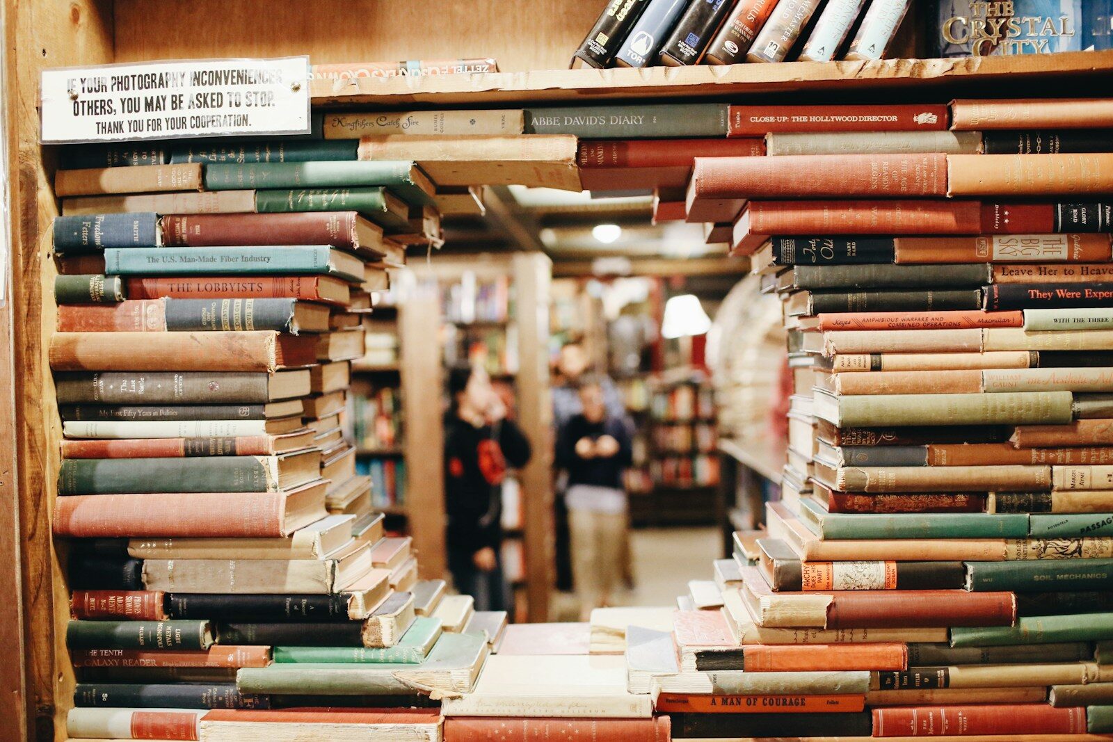 Stacked library books beside a window