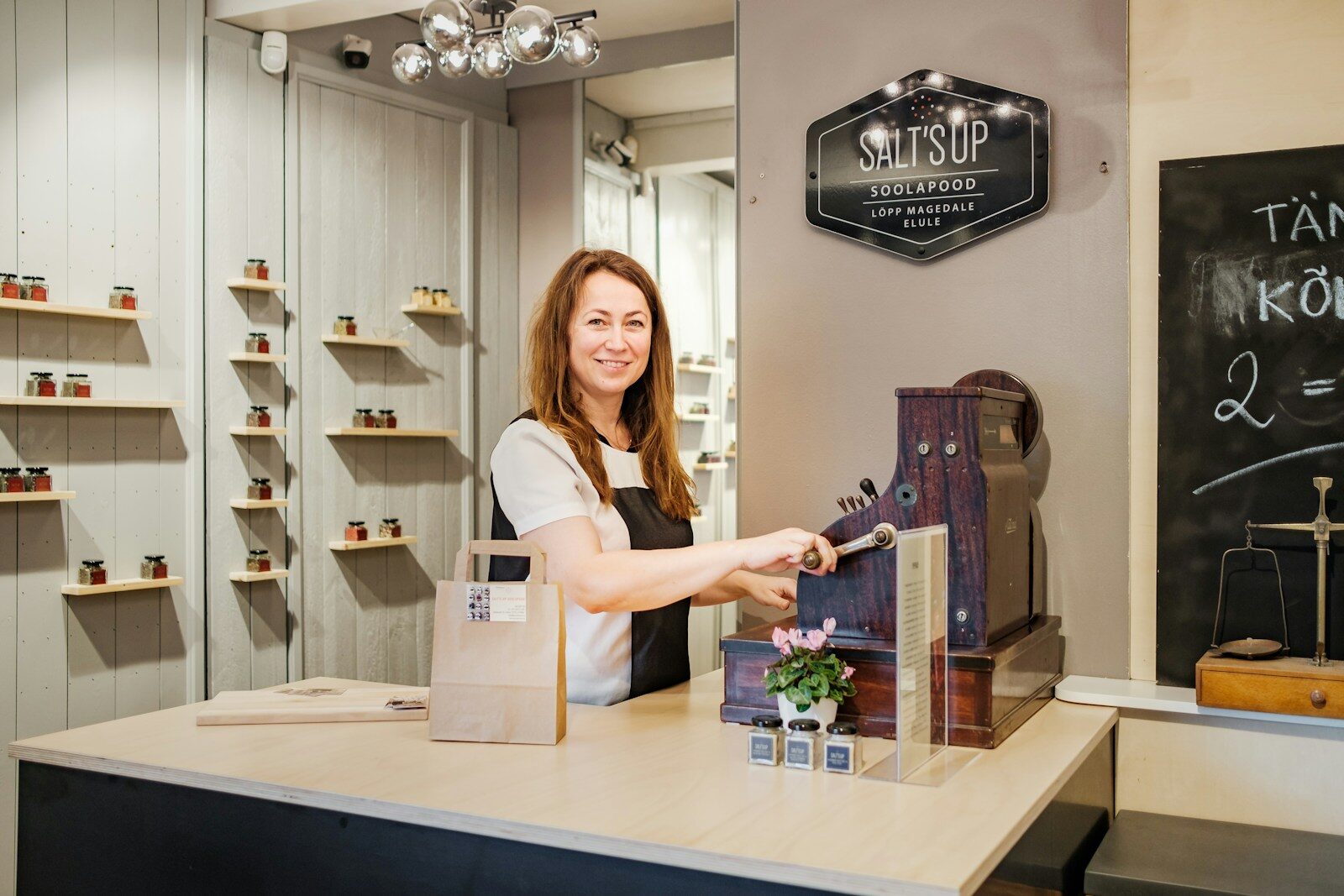A small business owner standing at a wooden counter in her shop