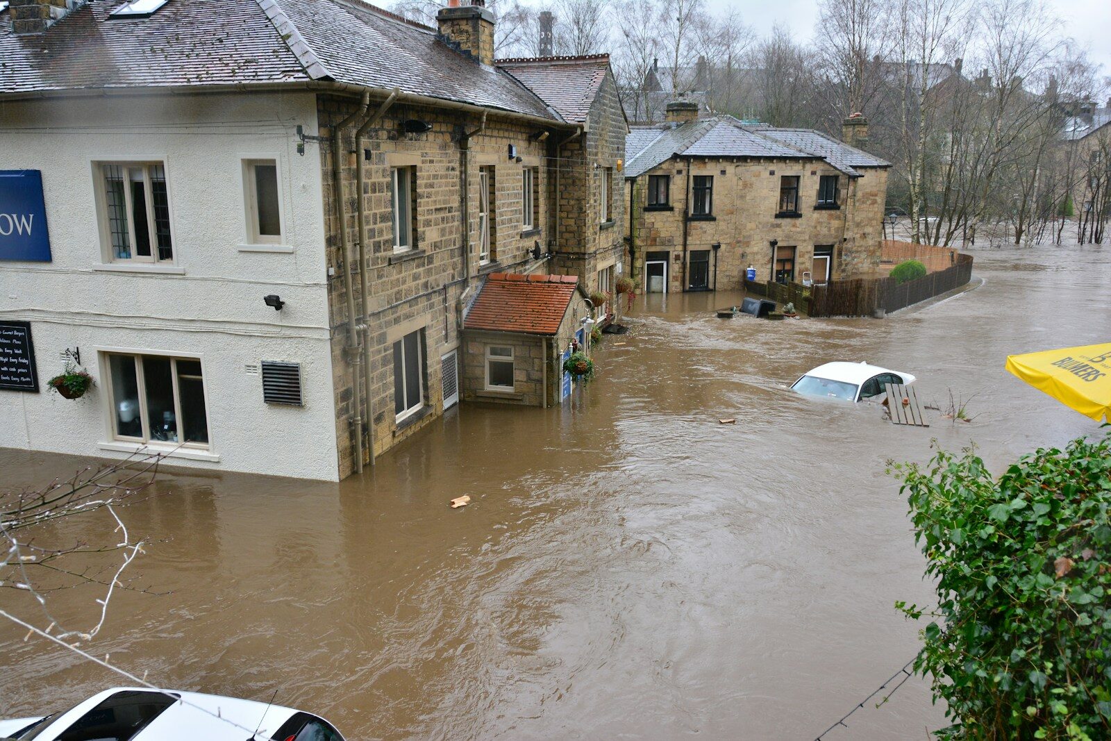 A house standing on a riverbank, exposed to the flooding whose cost is now disputed