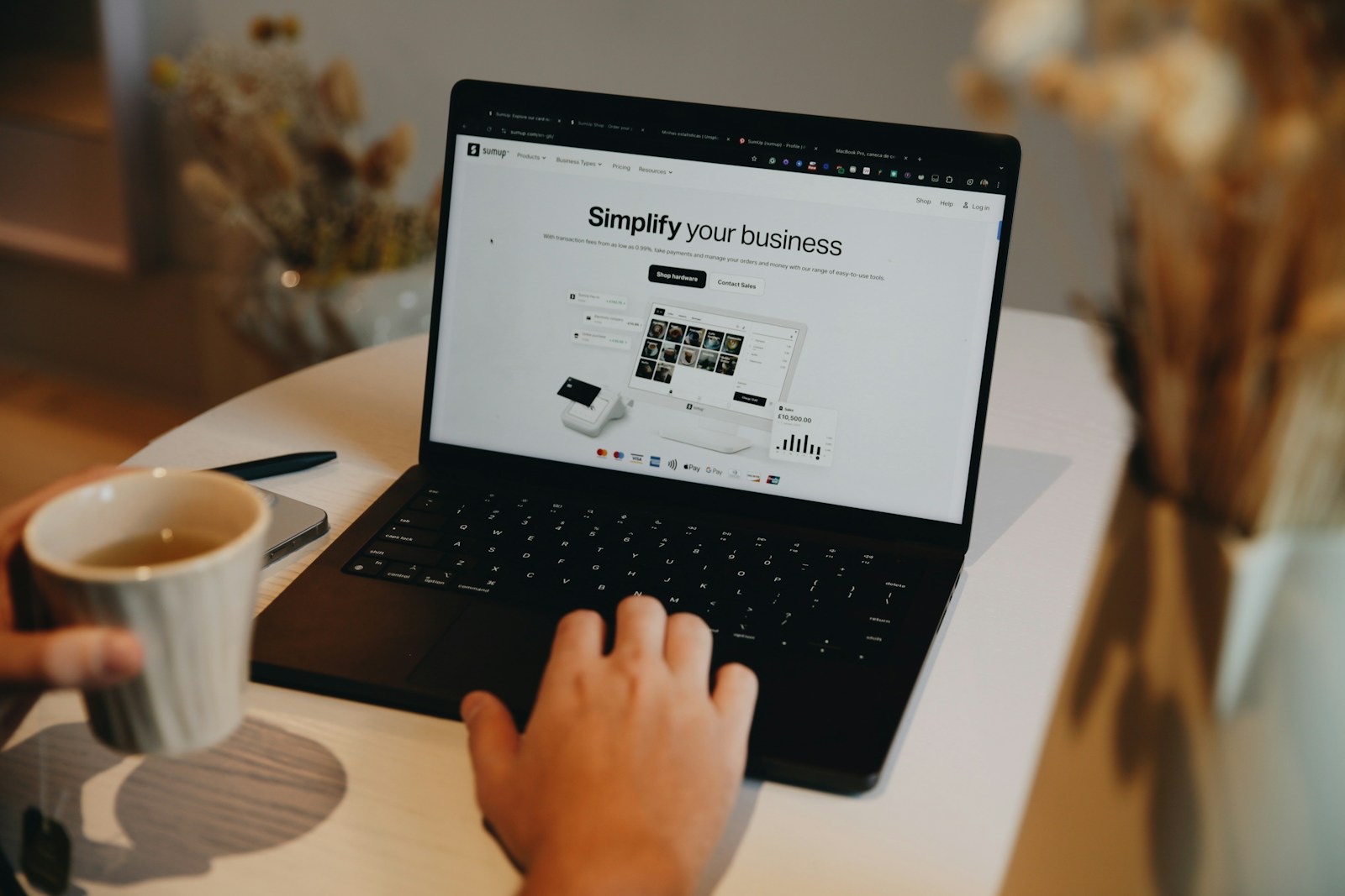 Viewing the SumUp website on a laptop, highlighting tools for small businesses, including payment systems and financial management solutions.