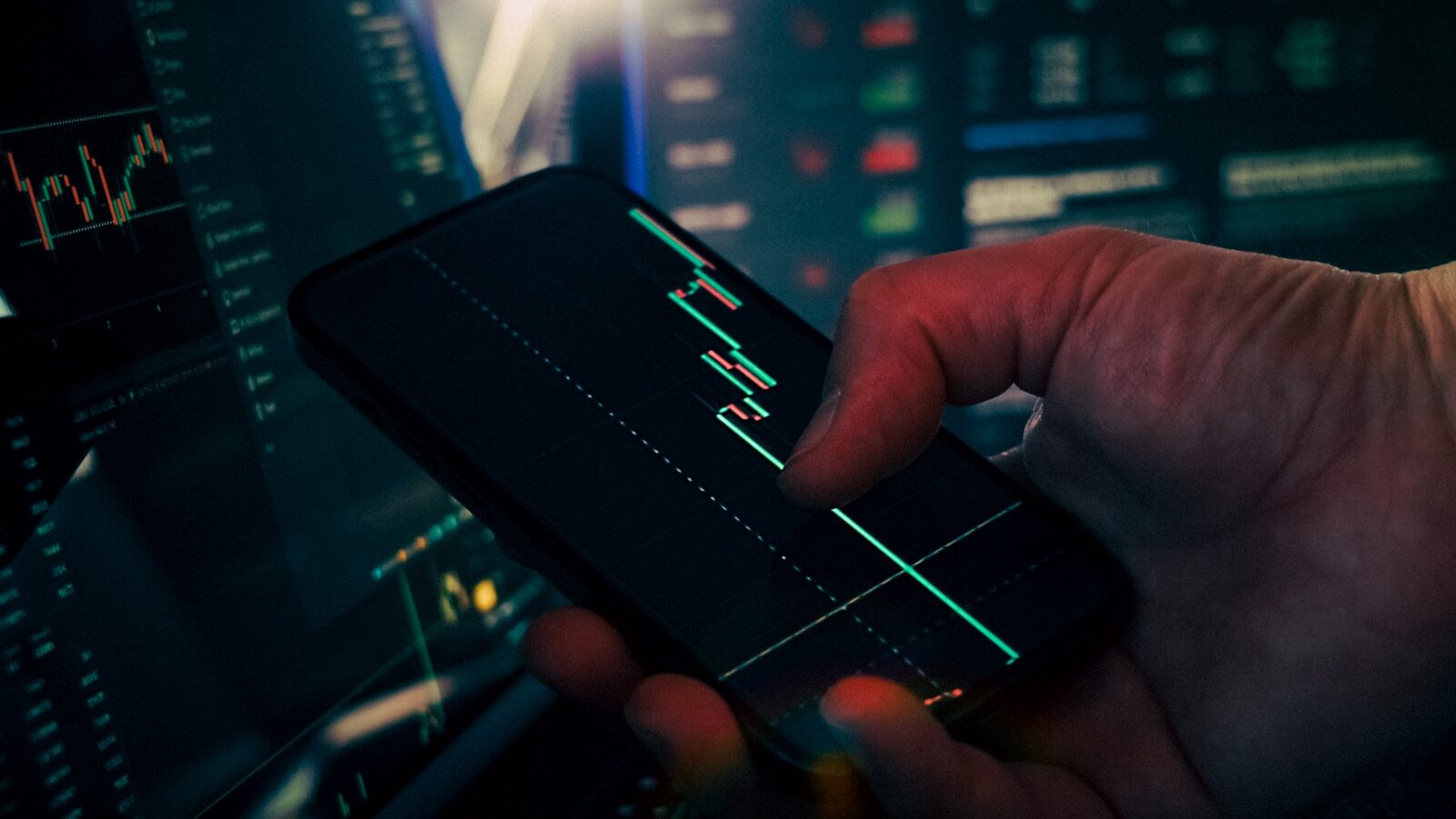 Hand smartphone trading chart technology finance background. Close-up of a person analyzing candlestick stock chart