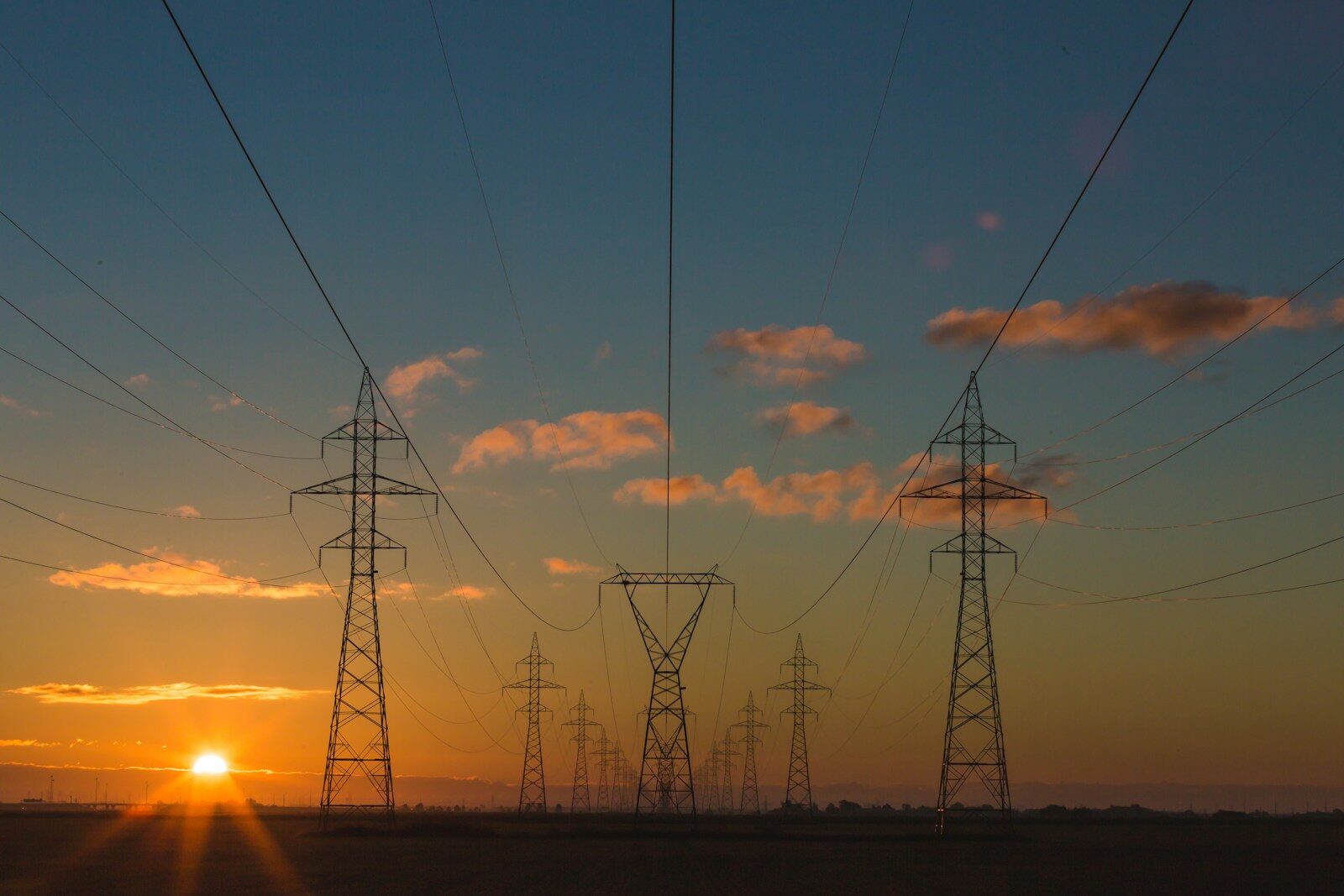 Steel transmission towers carrying high-voltage lines across open country