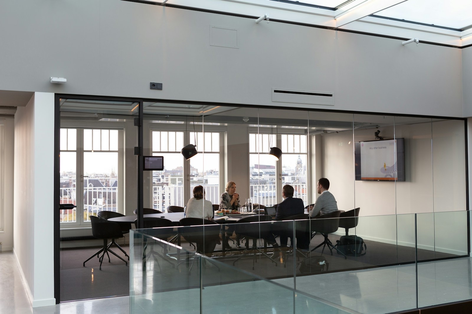 Colleagues talking around a table in an office meeting room.
