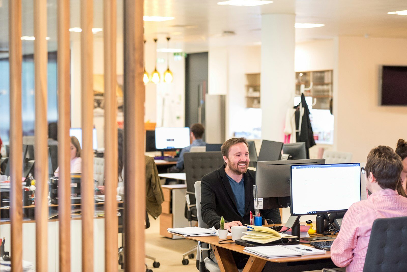 A man sitting at a desk in an open-plan office.