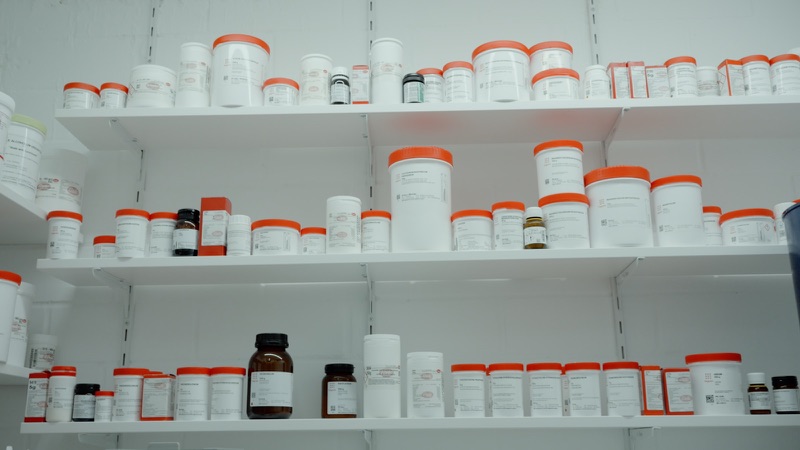 Shelves of labelled pharmaceutical containers in a dispensary.