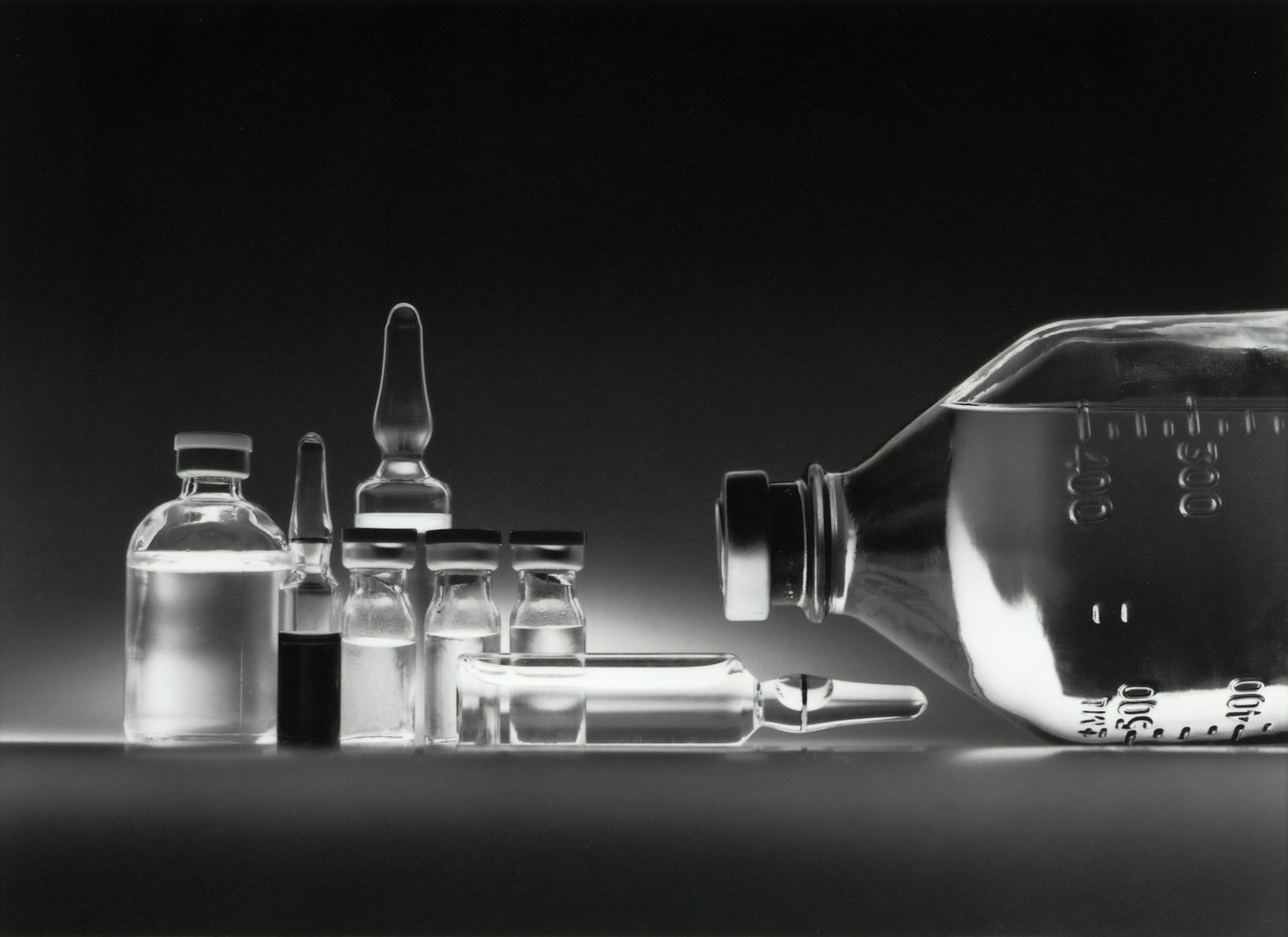 Chemotherapy drugs in vials beside an intravenous bottle.