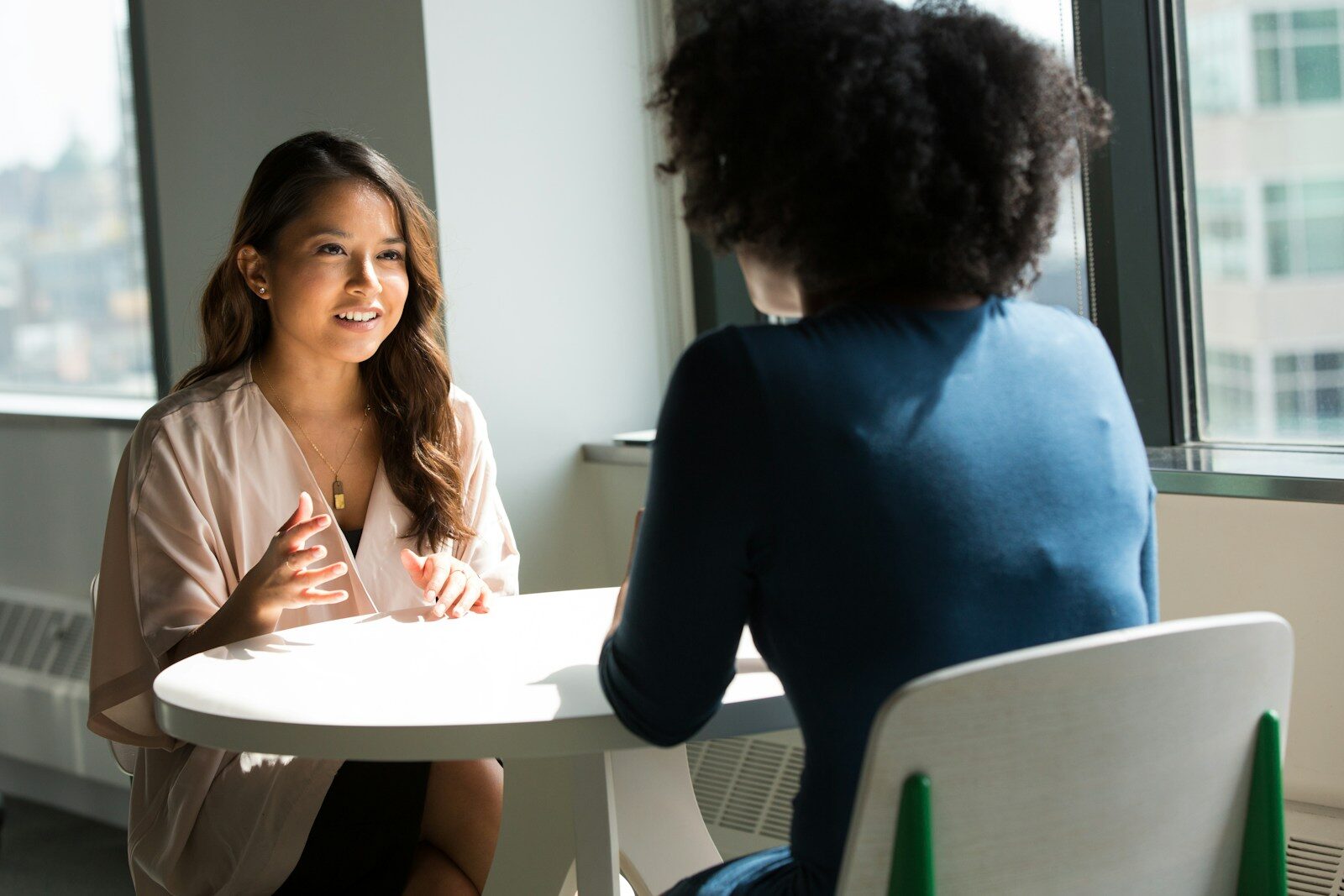 Two women seated across from each other during a job interview