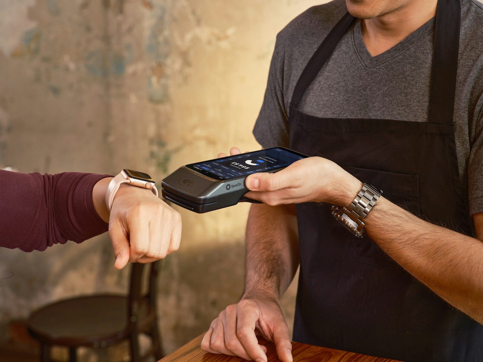 A customer paying by smartwatch at a payment terminal