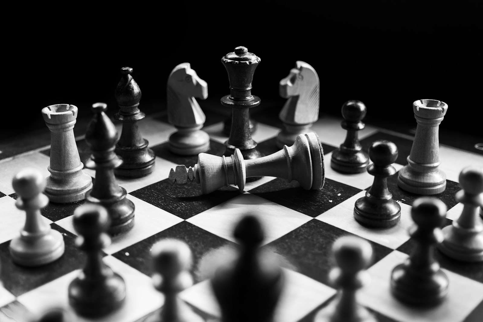 A chess board mid-game, pieces lit against a dark ground.