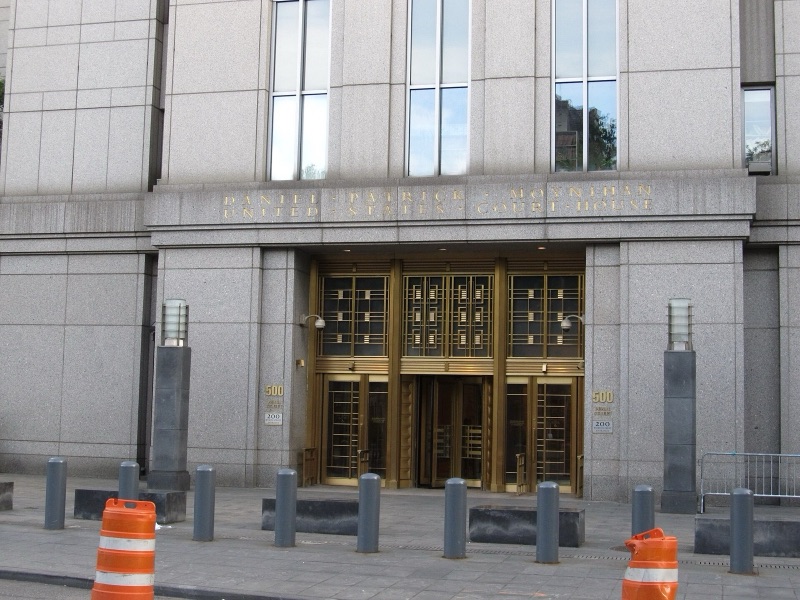 The granite entrance of the Daniel Patrick Moynihan United States Courthouse at 500 Pearl Street, with its name in gold letters above bronze doors and bollards along the pavement.