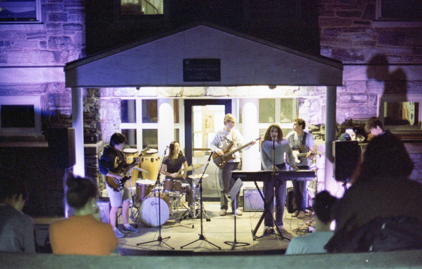 A band performing live on a small stage at night