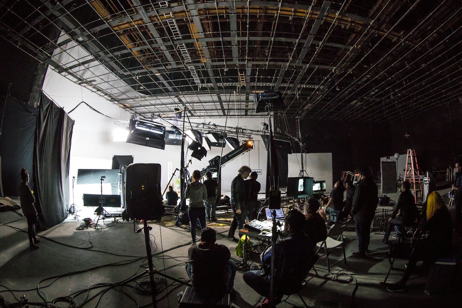 A film crew working around a camera on set.