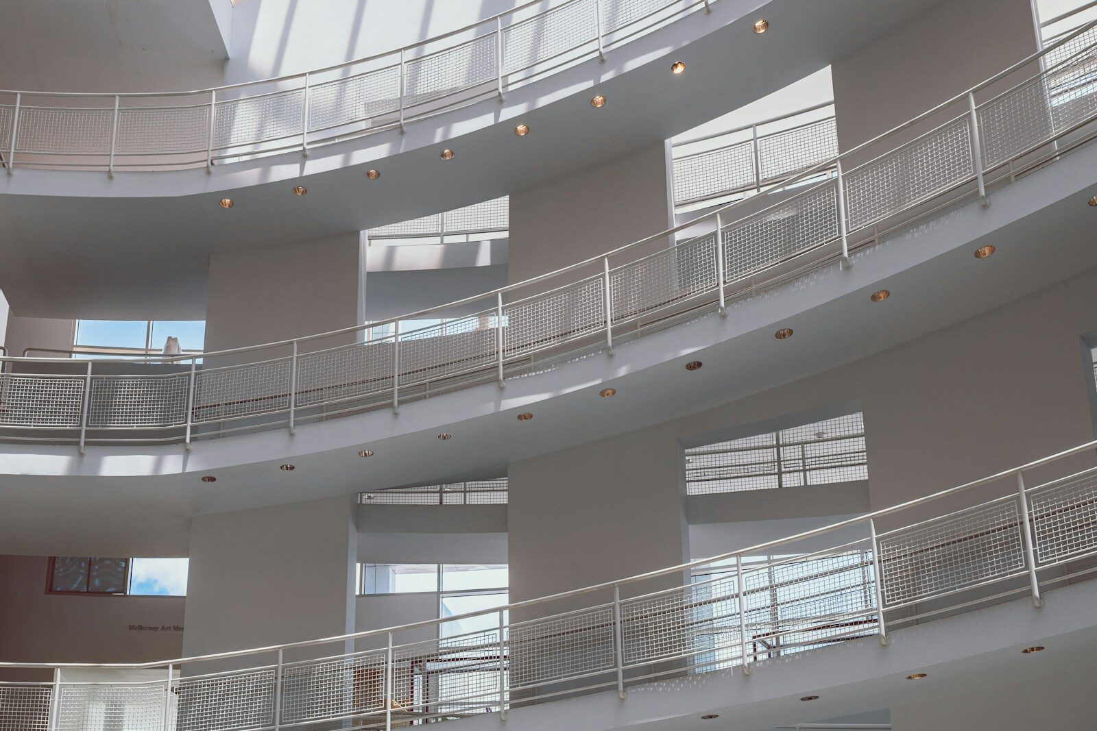 The interior of a contemporary art museum, with visitors in a top-lit gallery.