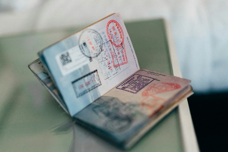 An open passport with several colourful entry and visa stamps, photographed in shallow focus.