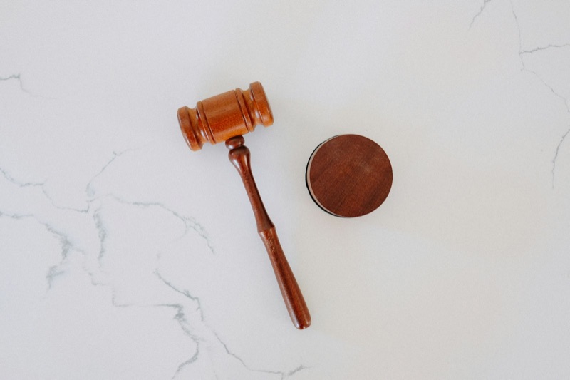 A wooden gavel resting on a marble surface.