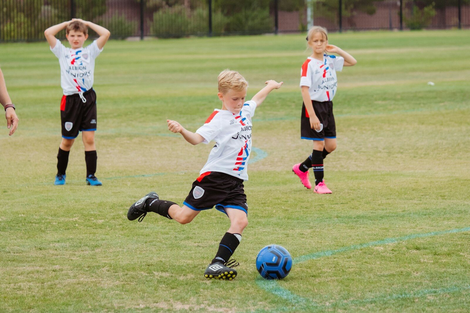 Four young players competing in a soccer match on a grass field